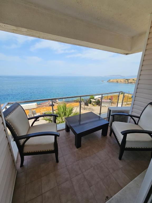 a balcony with chairs and a view of the ocean at erşan hotel in Foça