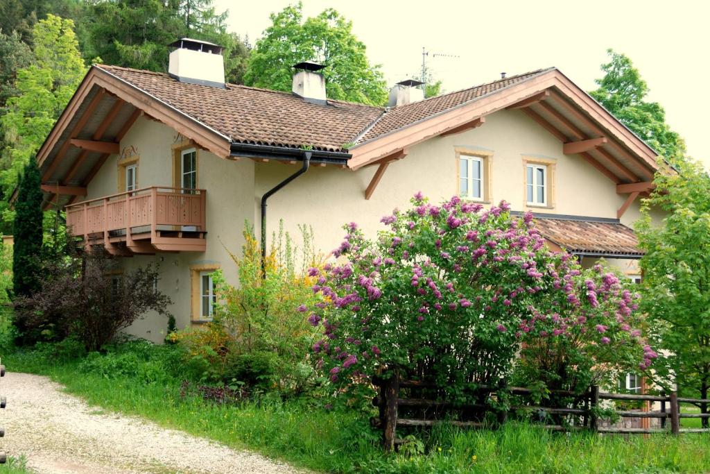 a house with a balcony and flowers in front of it at Ferienwohnung BERGKLANG in Nova Ponente