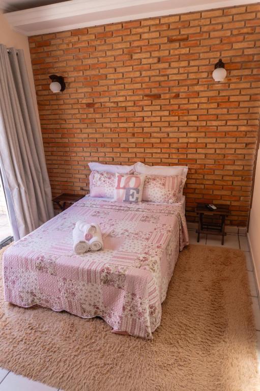 a bedroom with a bed with a stuffed animal on it at Recanto aconchego in Peruíbe