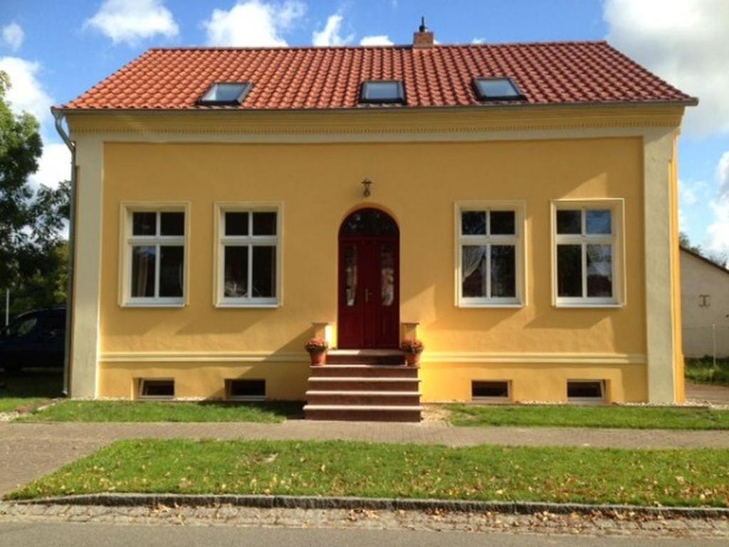 a yellow house with a red roof at Kleine Herberge in Strodehne