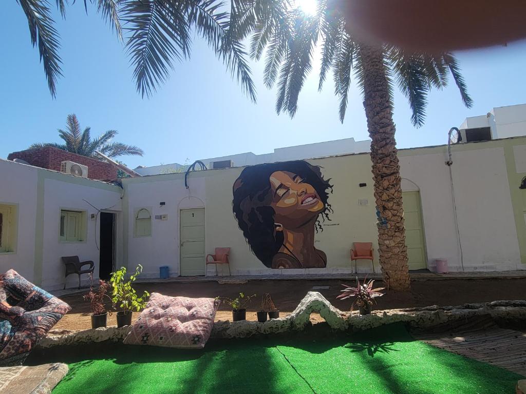 un murale di una donna sul lato di un edificio di Badya Camp بادية كامب a Dahab