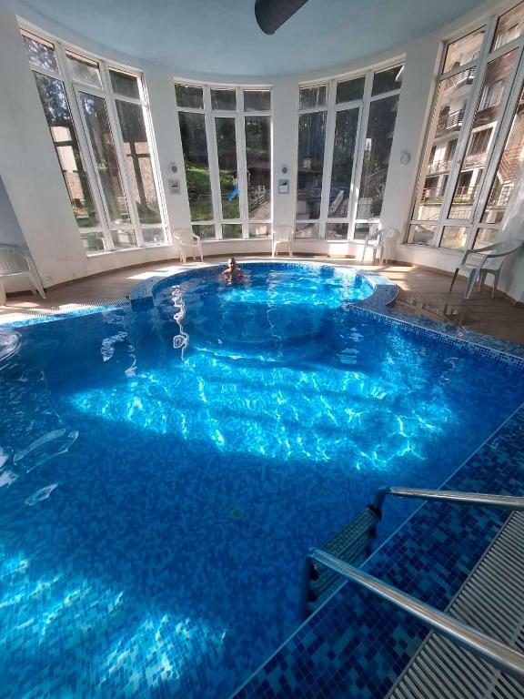 a large pool with blue water in a building at Pine Forest Apartments in Pamporovo