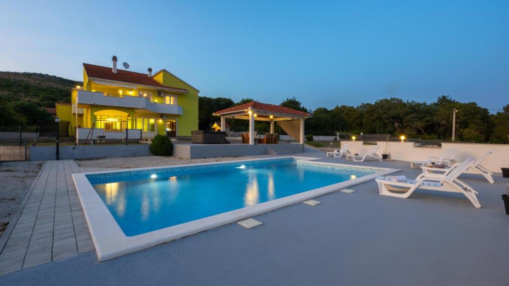ein Swimmingpool vor einem Haus in der Unterkunft Holiday home Neda by Villas Guide in Primorski Dolac