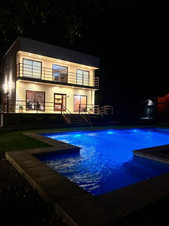 a house at night with a swimming pool in front of it at Home Quillon in Quillón