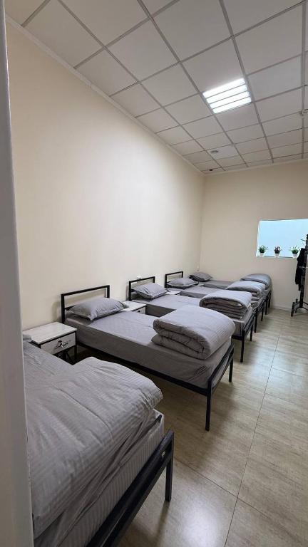 een rij bedden in een kamer bij Ugolok Xostel in Yakkasaray