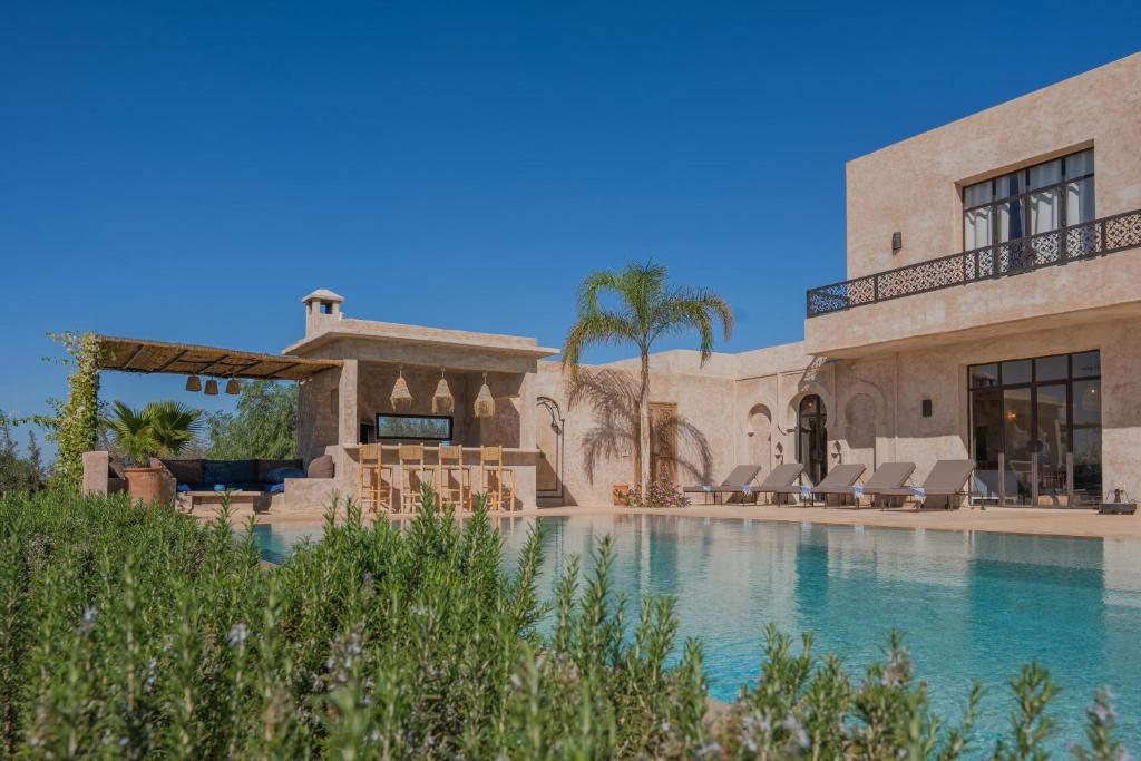 索维拉Lalla Essaouira, Villa Najma avec piscine pour 15 personnes的一座带游泳池和棕榈树的大房子