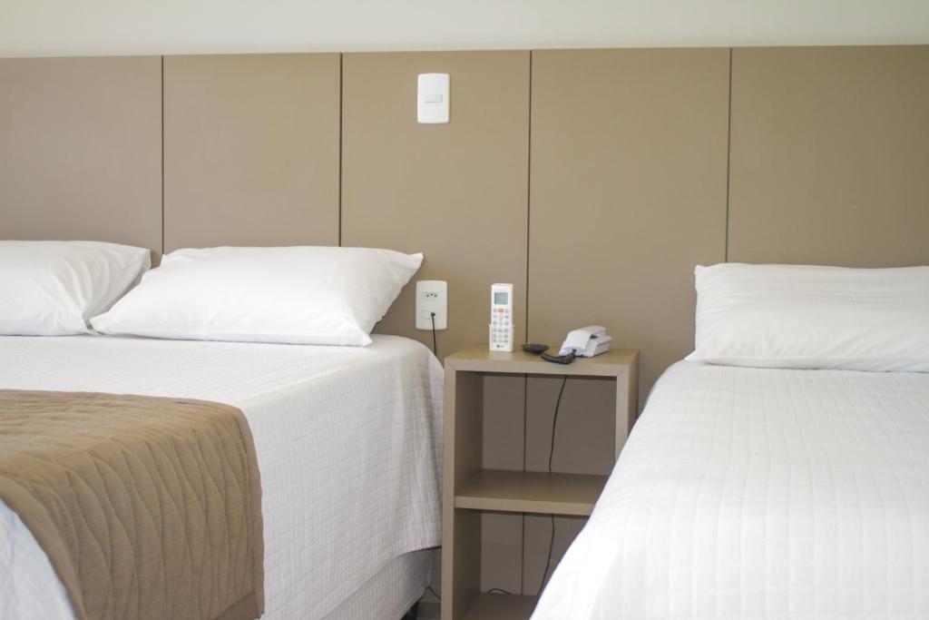 Telêmaco BorbaHotel Seville Comfort的房间里有两张并排的床