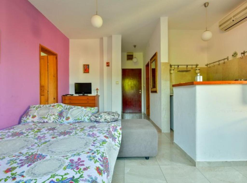 a bedroom with a bed and a pink wall at Villa Marković 2 in Sutomore
