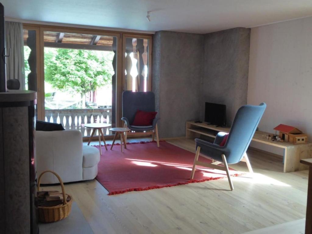 a living room with a couch and chairs and a table at Apartment Biala - BioBergün by Interhome in Bergün