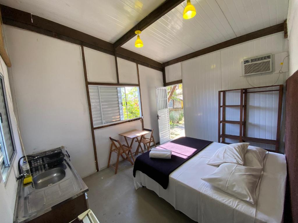 een slaapkamer met een bed en een wastafel bij Tree Park Cambury in Camburi