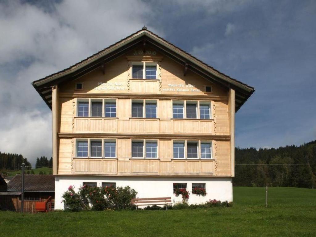 a large wooden house with windows on a field at Apartment Hautle by Interhome in Eggerstanden - Appenzell