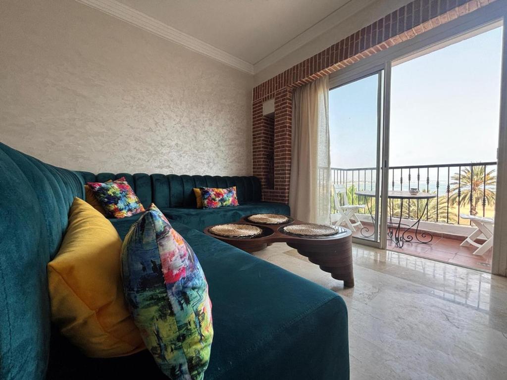 a living room with a blue couch and a large window at marina1 in Agadir