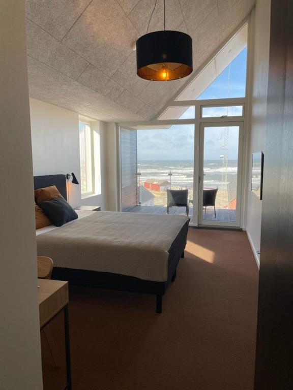 a bedroom with a bed and a view of the ocean at Hotel og Restaurant Havbadet in Thisted