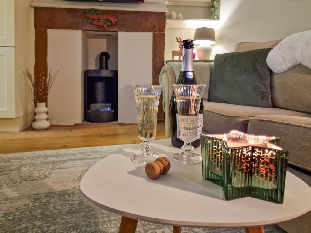 een tafel met een fles wijn en twee glazen bij Thimble Cottage in St Bees