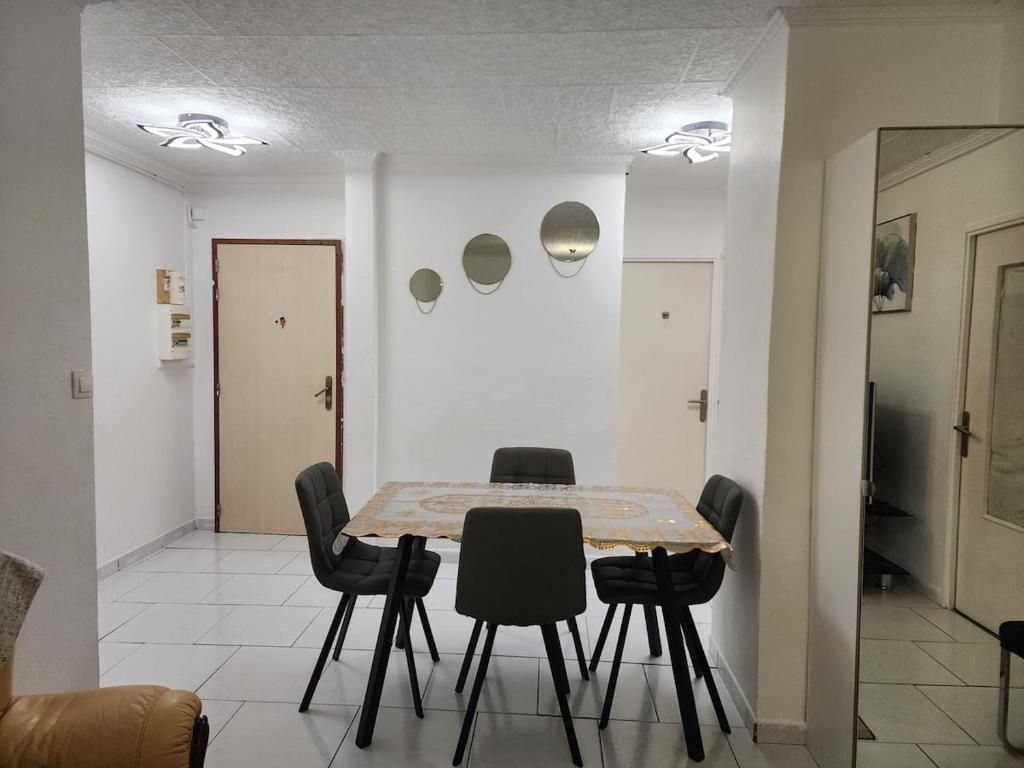 une salle à manger avec une table et des chaises noires dans l'établissement Bright apartment 1 to 3 bedrooms, à Besançon
