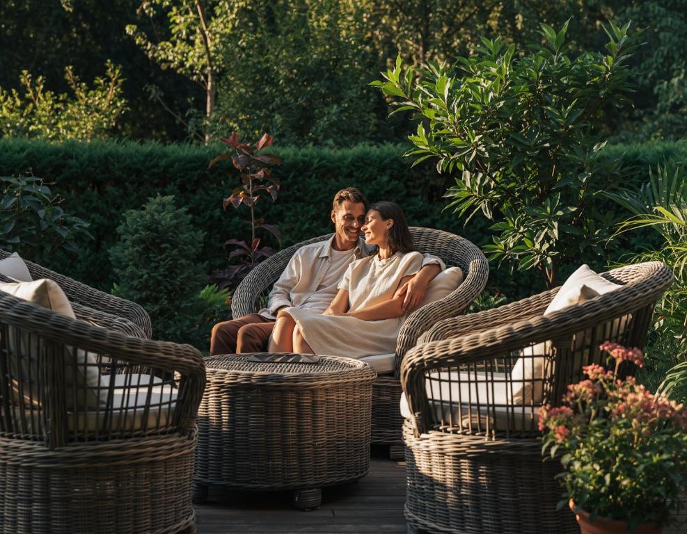 a man and a woman sitting in wicker chairs at Appartement Borger mit Garten in Sauerlach