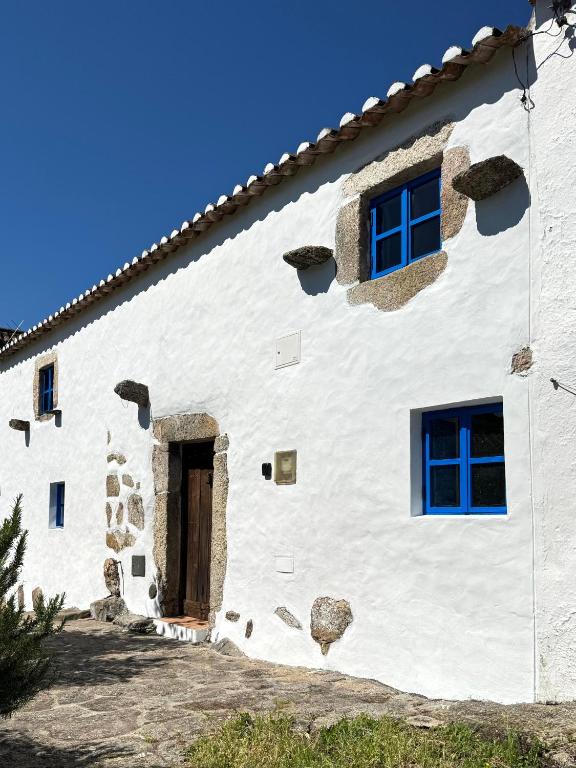 a white building with a door and windows at Casa Com Mãos in Marvão