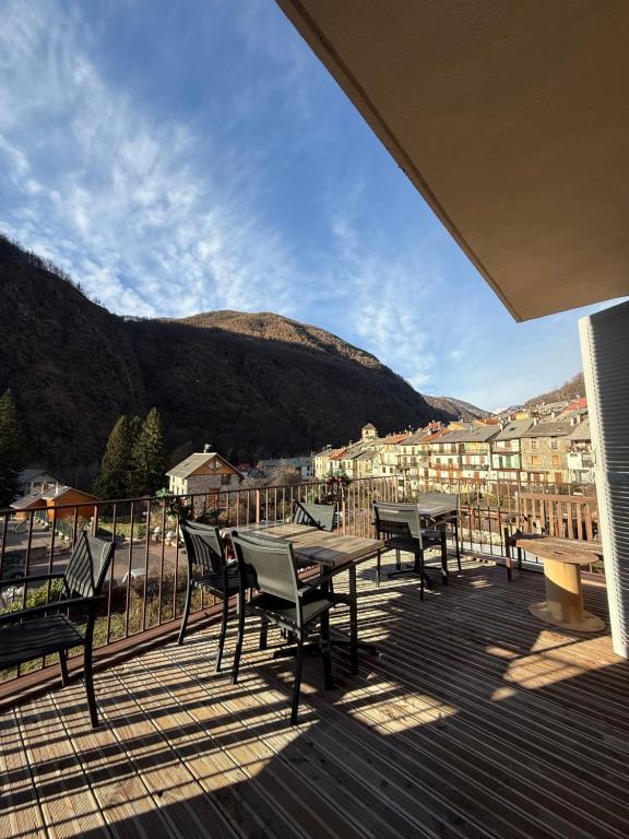a deck with tables and chairs and a view of a city at Le Touring in Isola