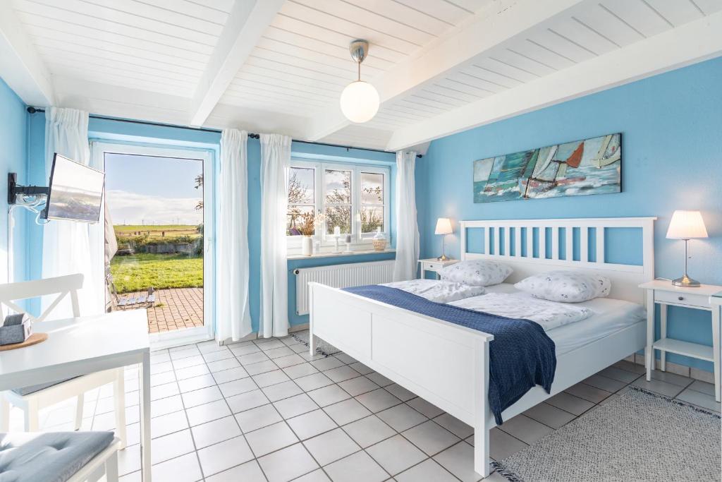 una camera da letto blu con un letto e una finestra di Schipp Landen Lisa a Schobüll