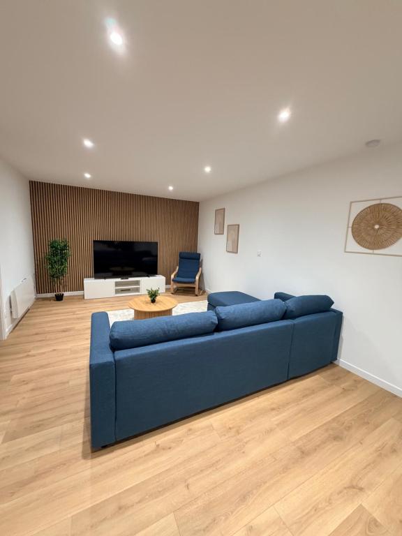 un soggiorno con un divano blu e una TV di L élégance centre historique Dole 70 m2 a Dole