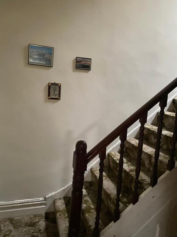 een trap met drie foto's aan de muur bij Mickys Bed and Breakfast in Ramsgate