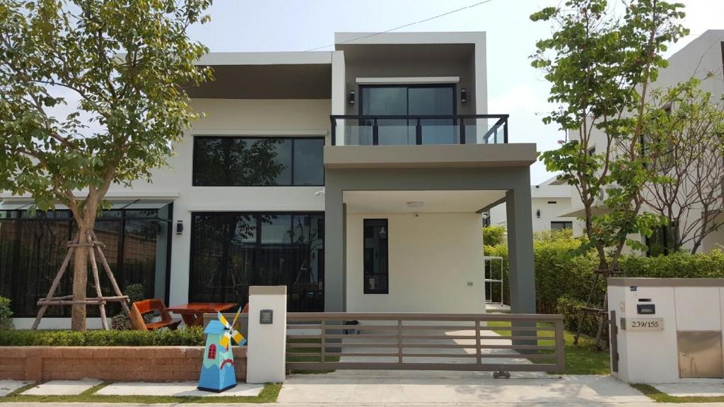 a modern house with a balcony in front of it at Shalom Casa Seaside Rayong in Ban Chak Phai