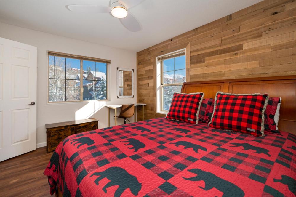 a bedroom with a bed with a red and black blanket at Waterside West A303 in Fraser