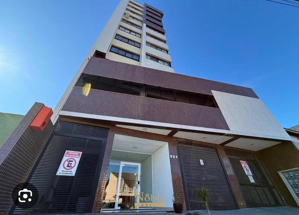 un bâtiment avec un grand immeuble en arrière-plan dans l'établissement Apto torres, à Torres