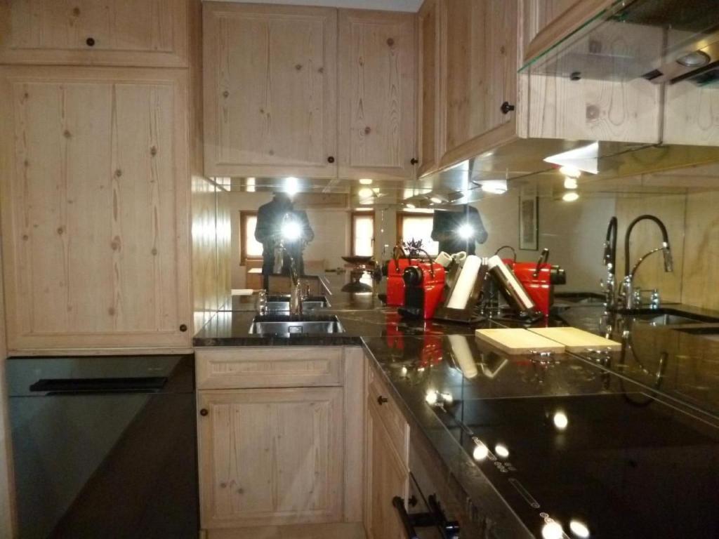 a kitchen with wooden cabinets and a black counter top at Apartment Chesa Blais by Interhome in Zuoz