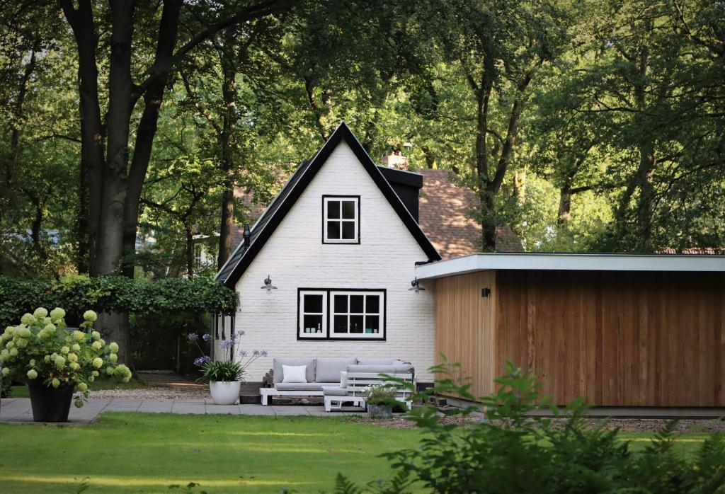 a white house with a bench and a fence at Forest Inn in Ugchelen