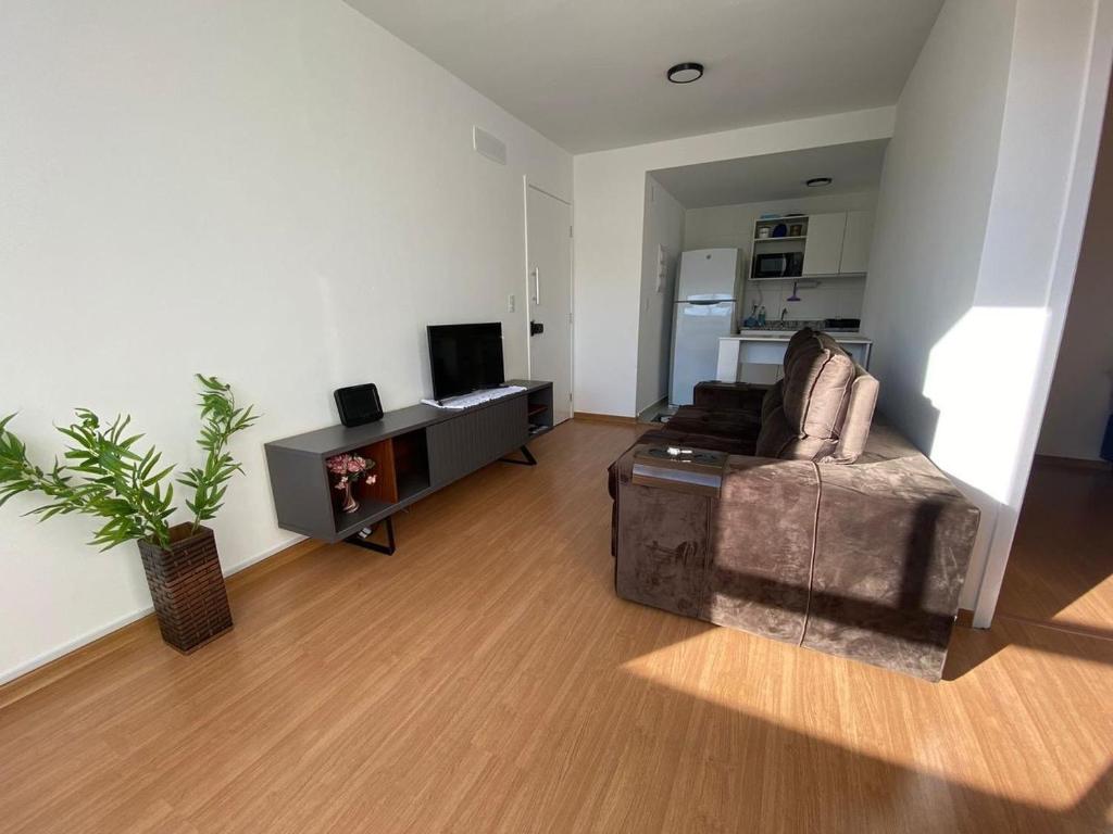 un soggiorno con un divano e una TV di Apartamento proximo centro a Poços de Caldas