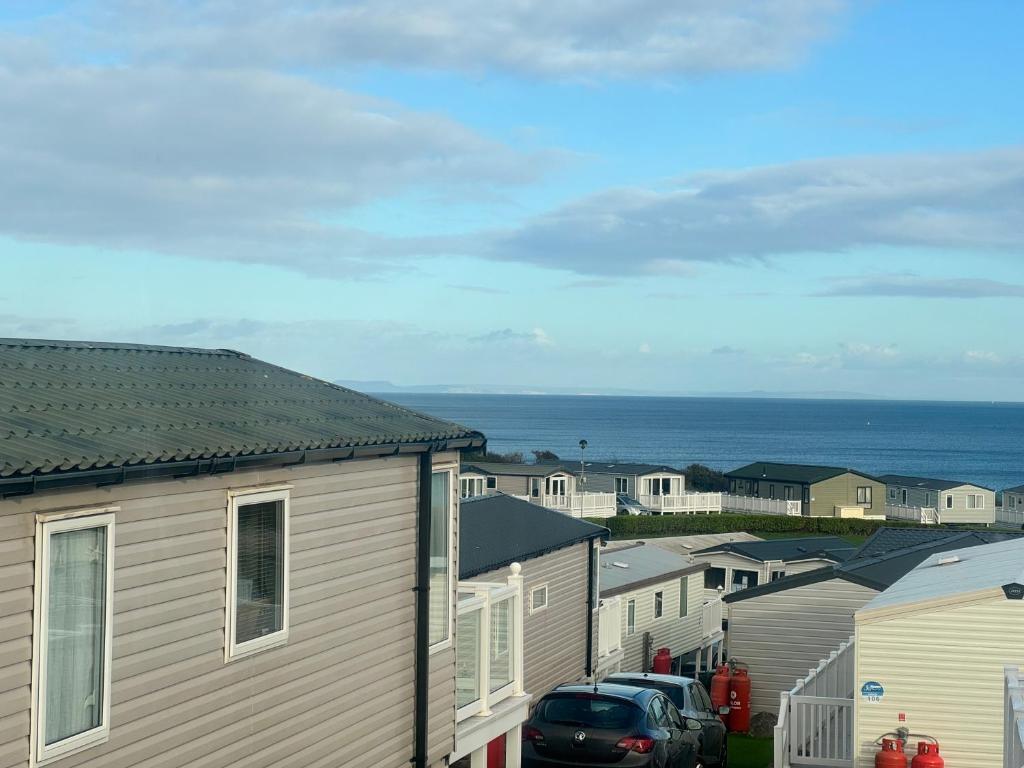 a row of houses with the ocean in the background at The Pilot s Rest sleeps 6 in Exmouth