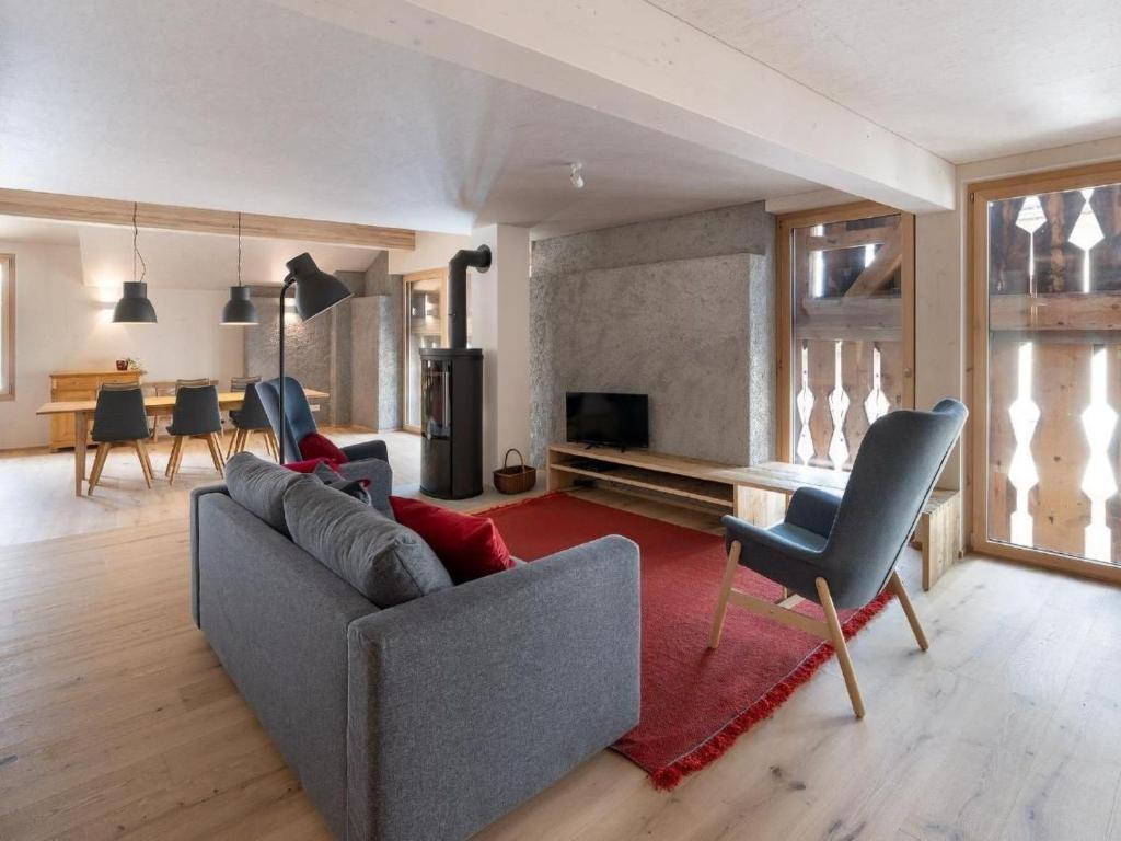 a living room with a gray couch and a red rug at Apartment Bellezza - Bio Bergün by Interhome in Bergün