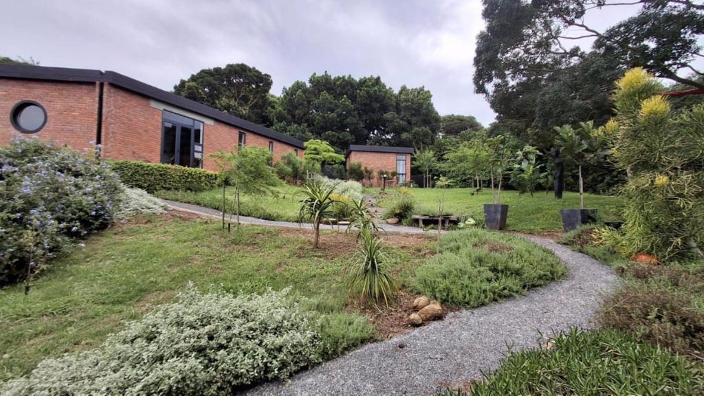 a garden in front of a brick building at Lakritz A Place of Experience through Art in Chintsa