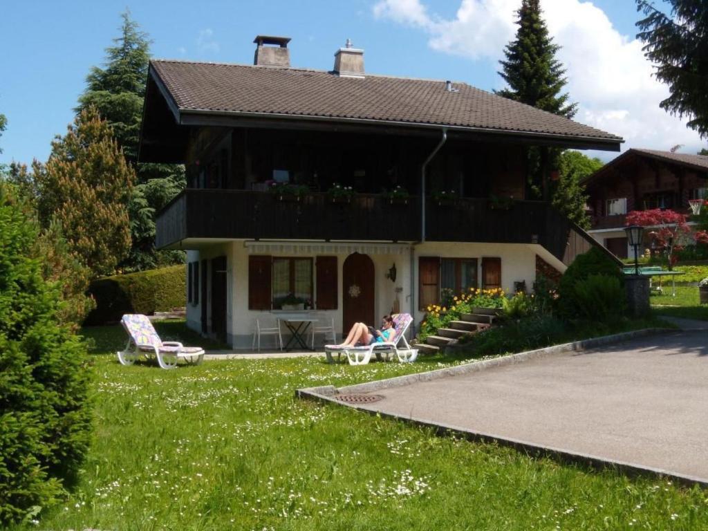 a couple sitting in chairs in front of a house at Apartment Akalei by Interhome in Aeschi