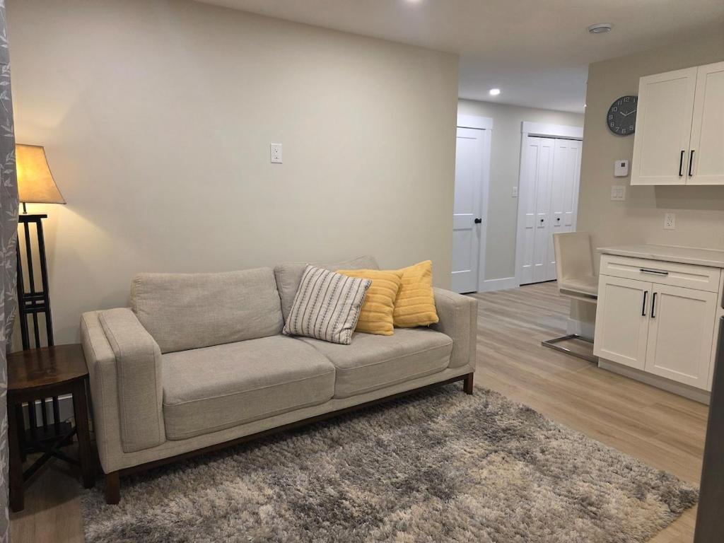 een woonkamer met een bank en een keuken bij Quiet Comfort Suite in Moncton