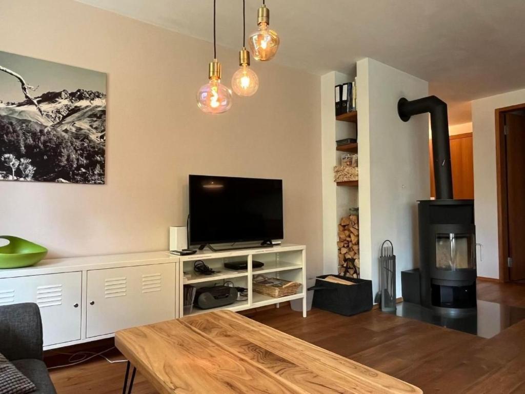 a living room with a flat screen tv and a fireplace at Apartment Chasa Ernst by Interhome in Zernez