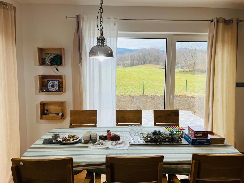 a dining room with a table and a large window at Ubytování Jitřenka in Černá Voda