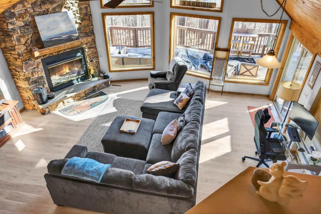 een woonkamer met twee banken en een open haard bij 3 Fireplaces Hot Tub Fire Pit Deck Pool Access in Hedgesville