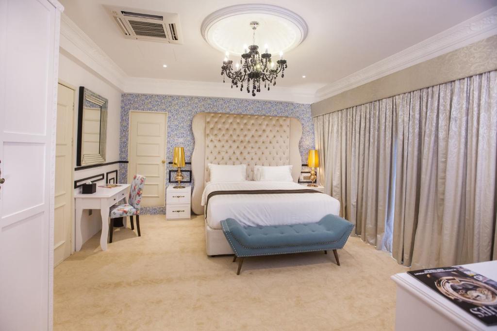 1 dormitorio con 1 cama extragrande y lámpara de araña en Apple Heritage Hotel, en George Town