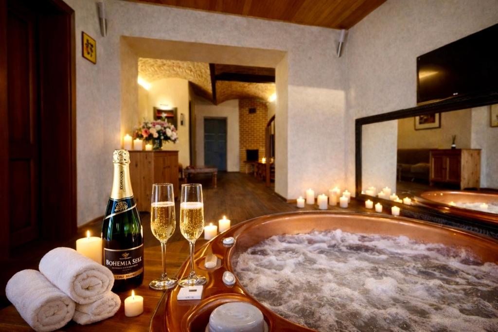 een bad met een fles champagne en kaarsen bij Amrita in Golčŭv Jeníkov