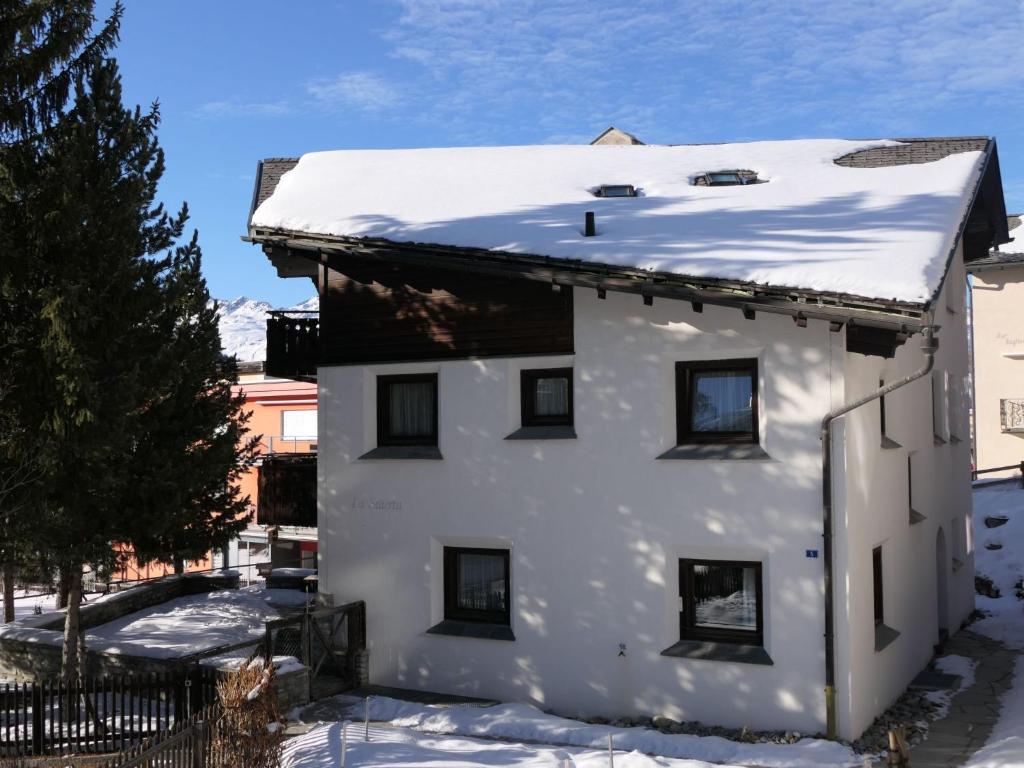 a white house with snow on the roof at Apartment La Stüerta by Interhome in Pontresina