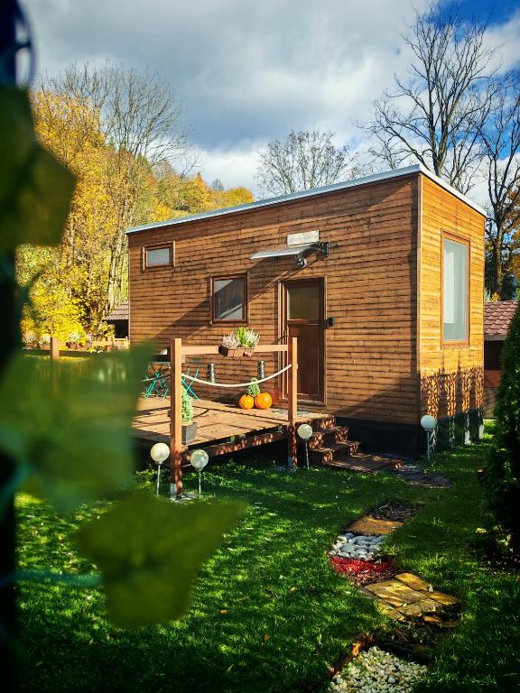 a tiny house with a deck in a yard at Malý kúsok raja in Reľov
