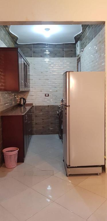 a kitchen with a refrigerator in the middle of a room at El BOB HOUSE in Luxor