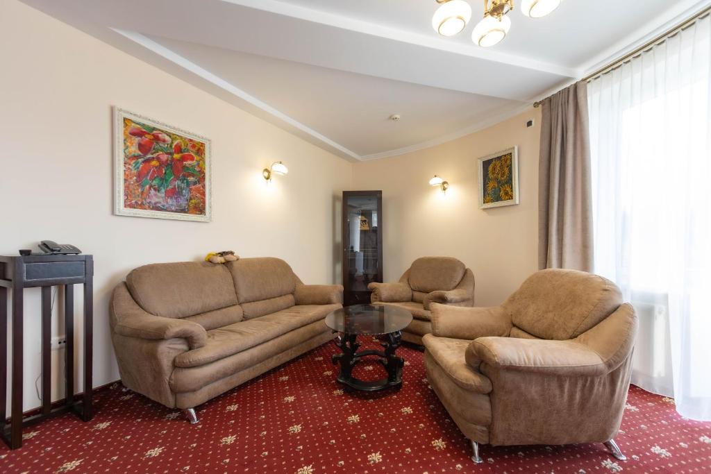 een woonkamer met twee banken en een tafel bij Dvorik Leva in Truskavets