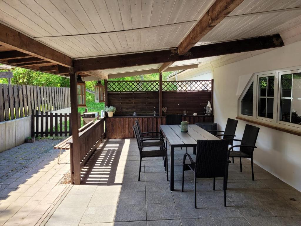eine Terrasse mit einer Holzpergola sowie einem Tisch und Stühlen in der Unterkunft Ferienwohnung 500m zum See in Klein Luckow