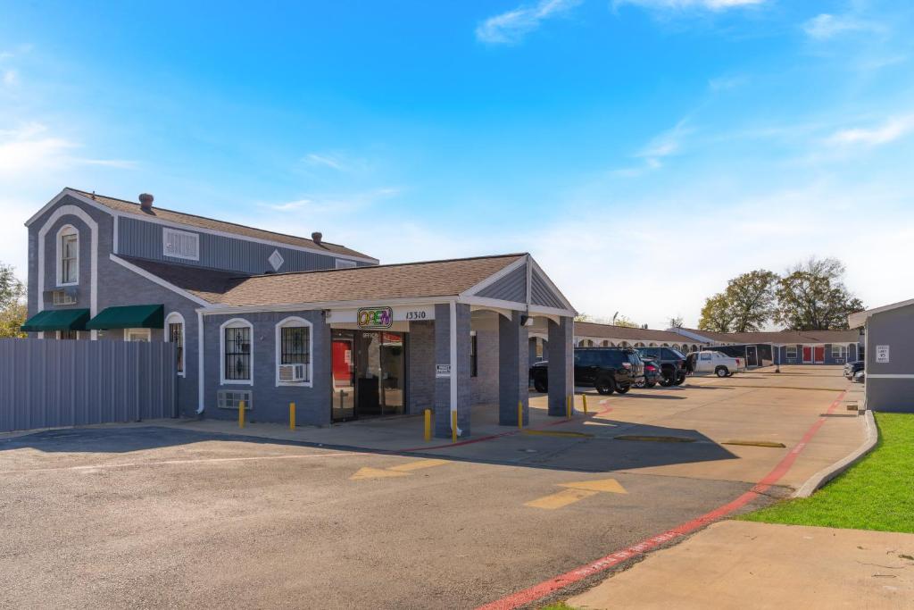un edificio in un parcheggio con auto parcheggiate di Golden Inn Dallas by Hotel O a Dallas