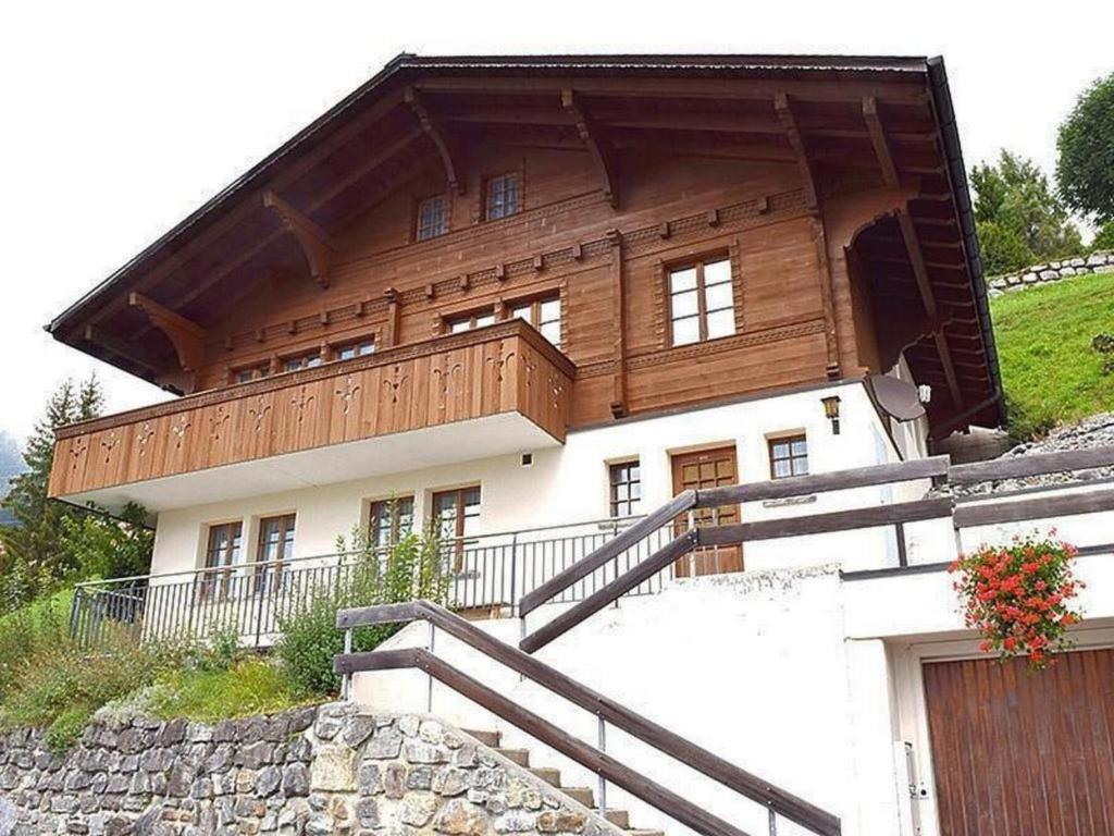 a house on top of a hill with a fence at Apartment Chalet Hofer by Interhome in Hasliberg Wasserwendi