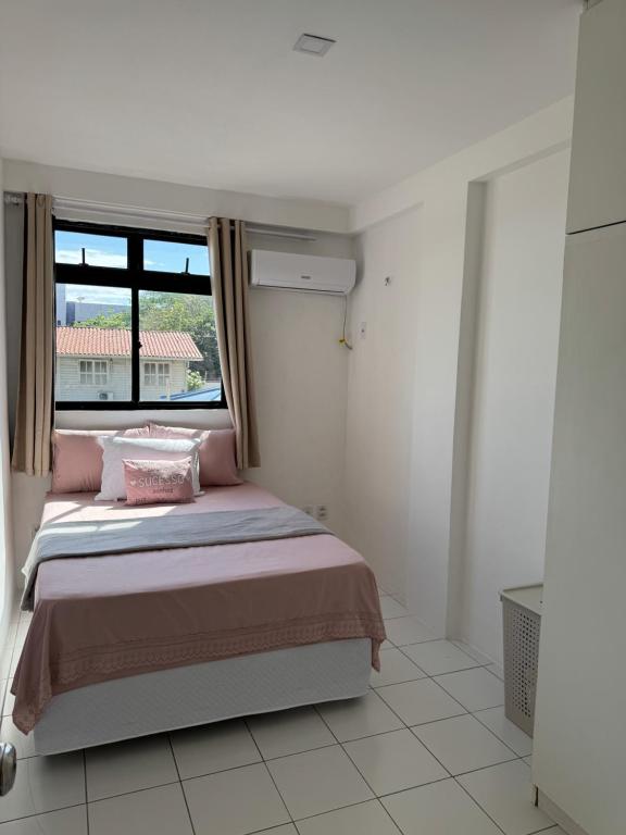 une chambre avec un lit et une fenêtre dans l'établissement Roma Garden, à São Luís