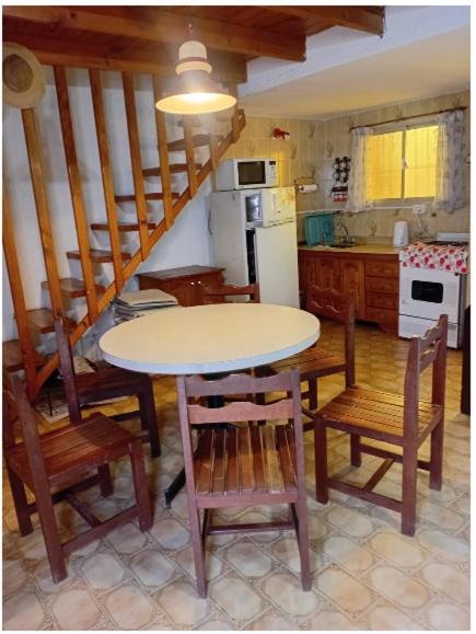 een keuken met een tafel en een aantal stoelen en een tafel bij PH Santa Teresita in Santa Teresita